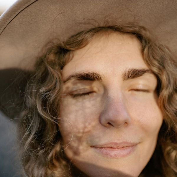 A person meditating peacefully with a calm expression on their face.